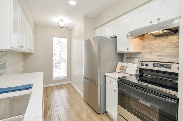 kitchen featuring stainless steel appliances, white cabinetry, tasteful backsplash, light hardwood / wood-style flooring, and light stone countertops