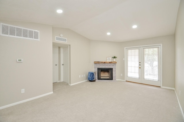 unfurnished living room featuring light colored carpet, vaulted ceiling, and a fireplace