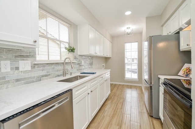 kitchen with electric stove, sink, dishwasher, light stone countertops, and white cabinets