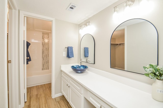 bathroom with vanity, hardwood / wood-style floors, and bathing tub / shower combination