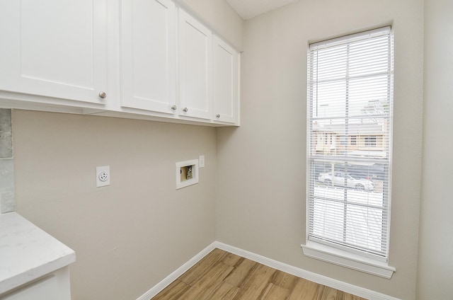 clothes washing area featuring cabinets, hookup for a washing machine, electric dryer hookup, and light hardwood / wood-style flooring