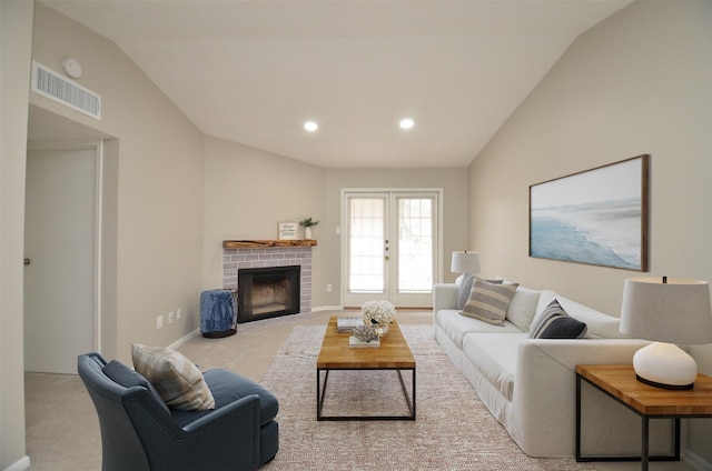 carpeted living room featuring lofted ceiling and a brick fireplace