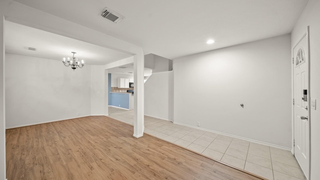 basement with a chandelier and light hardwood / wood-style floors