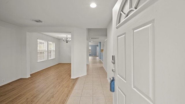 entrance foyer featuring light tile patterned floors and an inviting chandelier