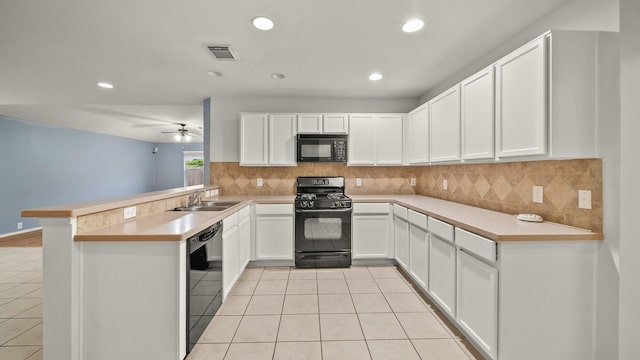 kitchen with kitchen peninsula, sink, white cabinets, and black appliances