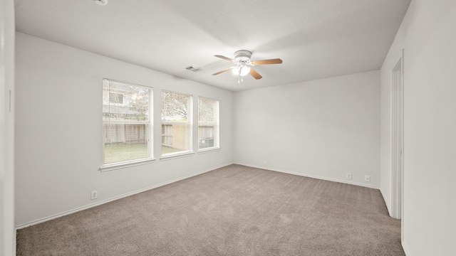 carpeted spare room featuring ceiling fan