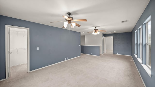 unfurnished room featuring light colored carpet and ceiling fan