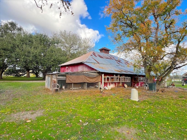 back of property with an outbuilding and a lawn