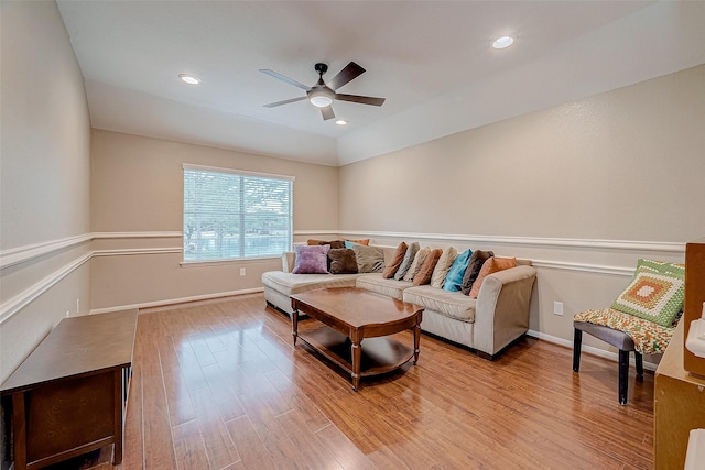 living room with light hardwood / wood-style floors, lofted ceiling, and ceiling fan