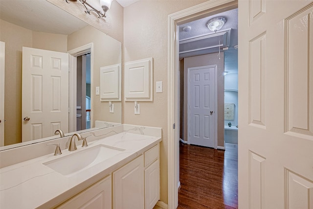 bathroom with hardwood / wood-style floors, vanity, and a textured ceiling