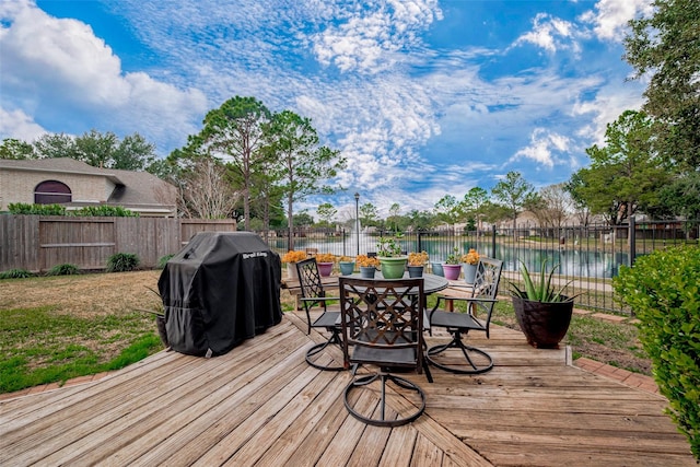 wooden terrace with grilling area and a water view