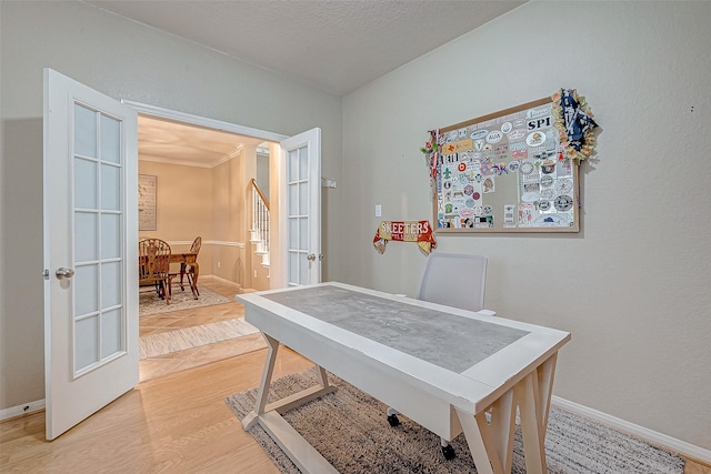 home office featuring hardwood / wood-style flooring, ornamental molding, and french doors