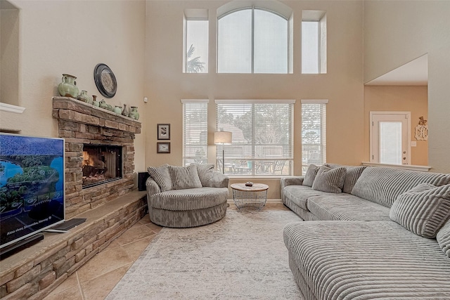 living room featuring light tile patterned floors, a towering ceiling, and a fireplace