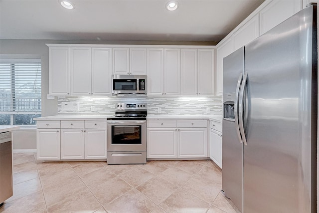 kitchen featuring tasteful backsplash, white cabinets, appliances with stainless steel finishes, and light tile patterned flooring