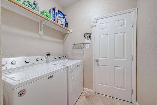 washroom featuring washing machine and dryer and light tile patterned floors