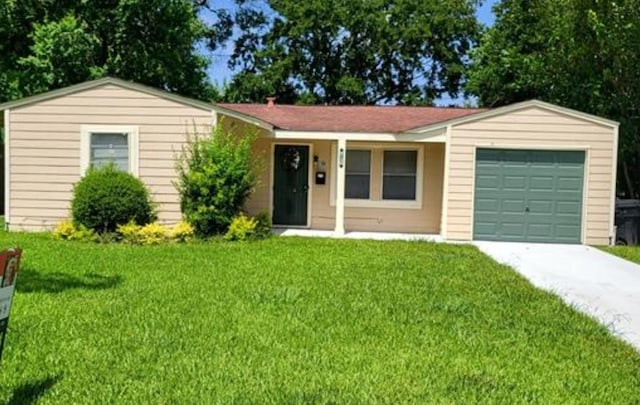 ranch-style home featuring a garage and a front lawn