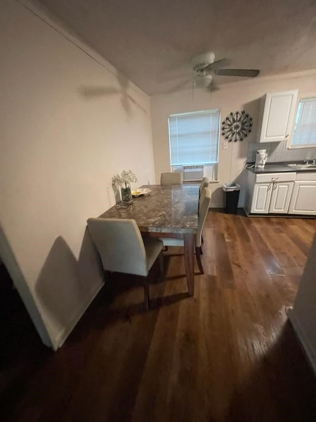 dining area featuring ceiling fan, sink, and dark hardwood / wood-style flooring