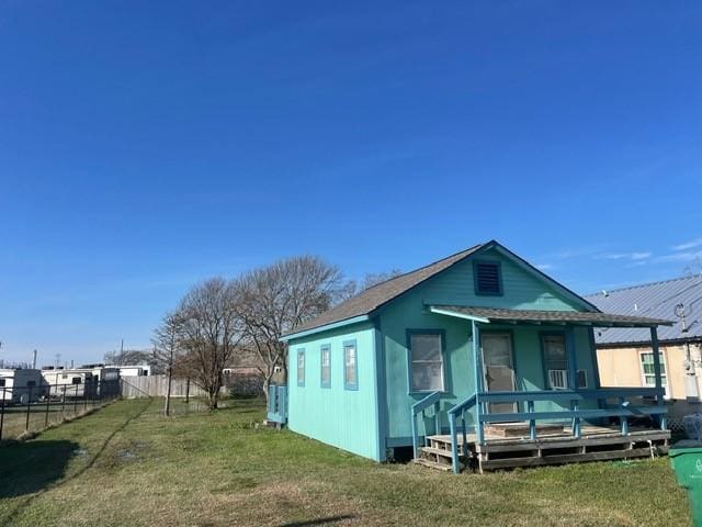 rear view of house featuring a deck and a yard