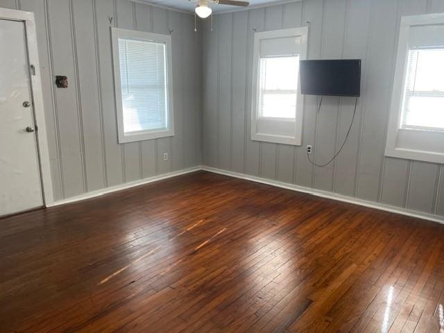 empty room with ceiling fan and dark wood-type flooring