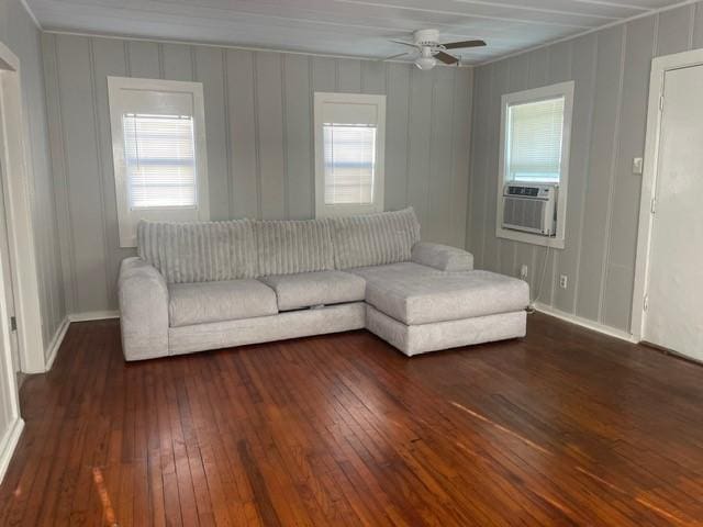 unfurnished living room with cooling unit, ceiling fan, and dark wood-type flooring