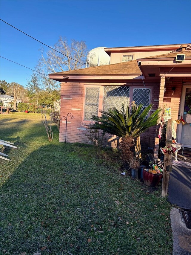 view of side of home with a lawn