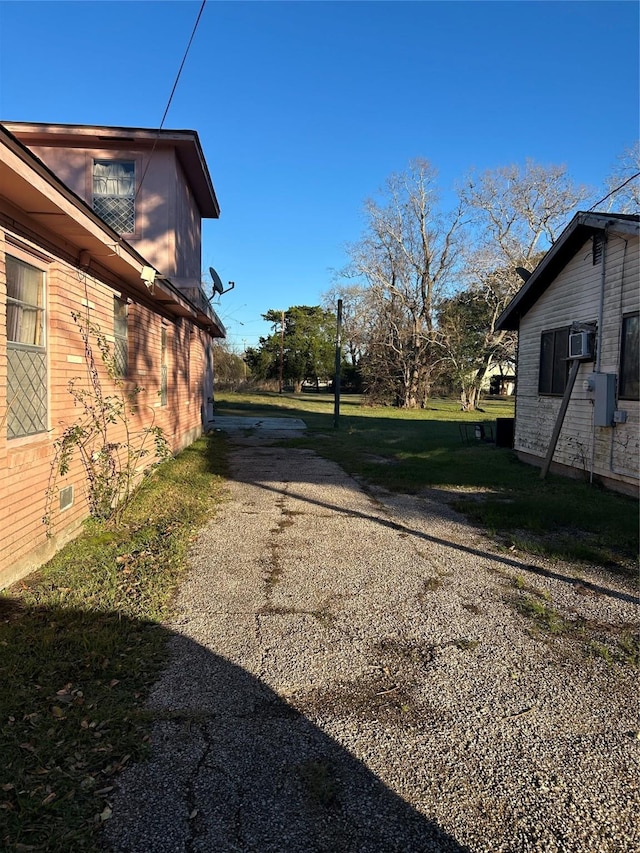 view of home's exterior featuring driveway, brick siding, crawl space, and a yard