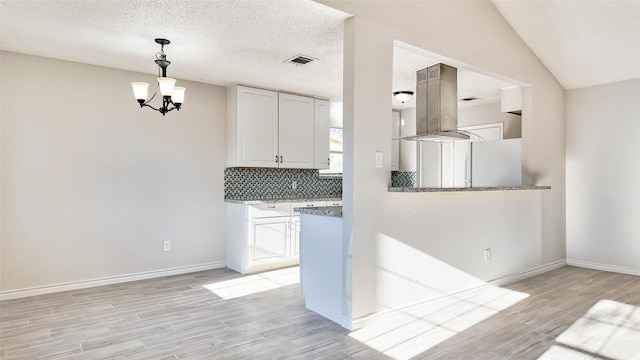 kitchen featuring pendant lighting, white cabinetry, backsplash, and light hardwood / wood-style flooring