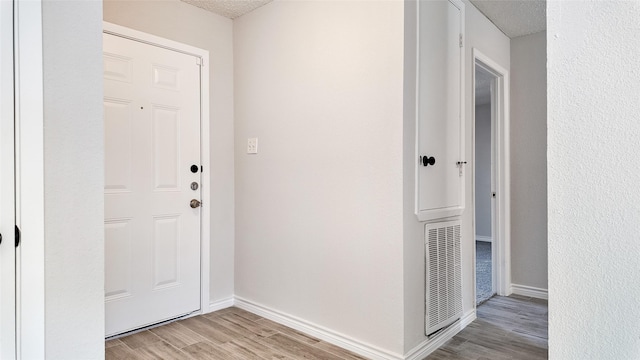 entryway featuring a textured ceiling and light wood-type flooring