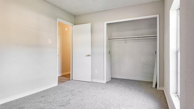 unfurnished bedroom featuring light carpet and a closet