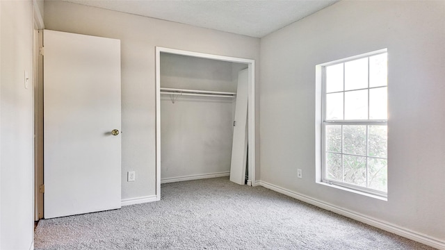 unfurnished bedroom featuring light carpet and a closet