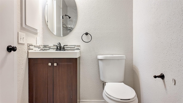 bathroom featuring vanity, toilet, and decorative backsplash