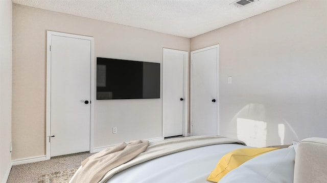 bedroom with light colored carpet and a textured ceiling