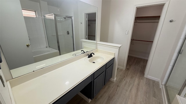 bathroom with hardwood / wood-style floors, vanity, and a shower with door