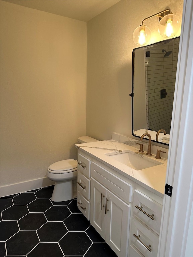 bathroom featuring vanity, toilet, and a tile shower