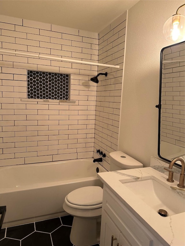 full bathroom with tile patterned floors, toilet, vanity, and tiled shower / bath