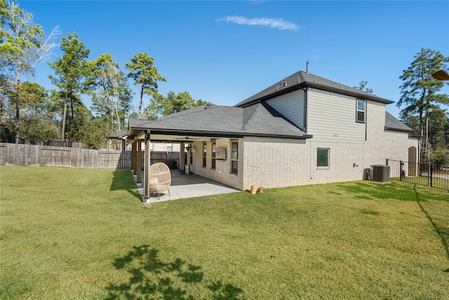 rear view of property featuring cooling unit, a yard, and a patio area