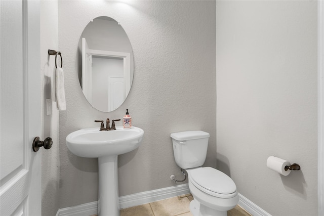 bathroom featuring sink, toilet, and tile patterned flooring