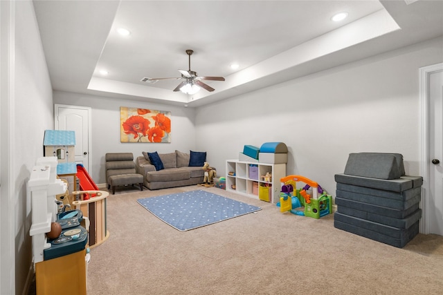 game room featuring a raised ceiling, ceiling fan, and carpet