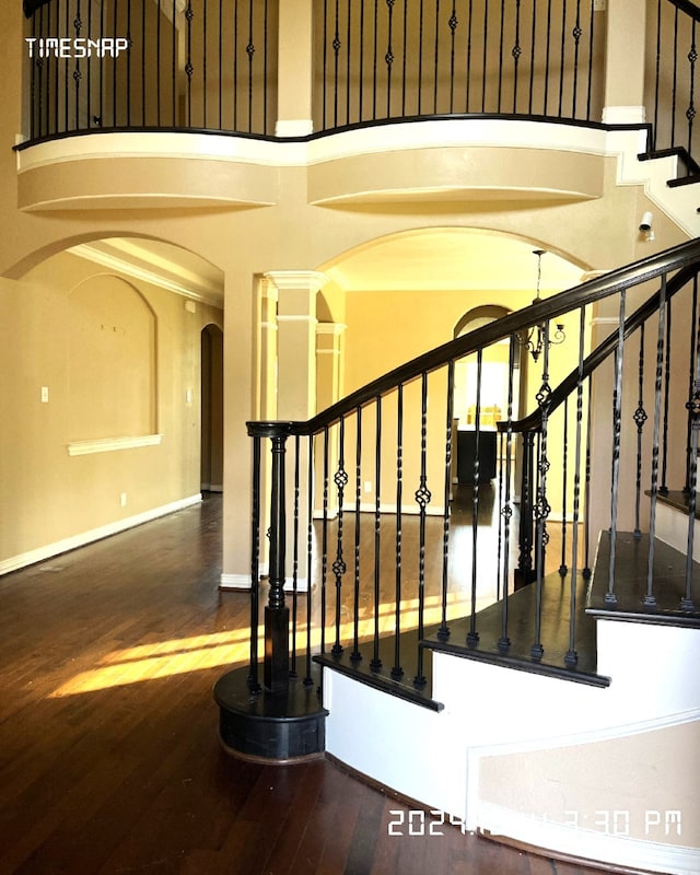 stairway with an inviting chandelier and hardwood / wood-style flooring