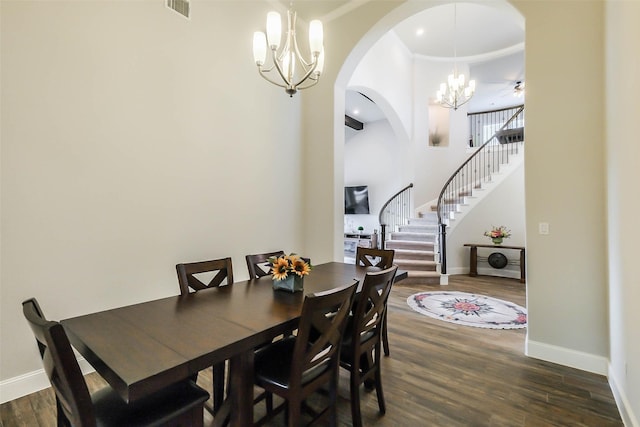 dining space with dark wood-type flooring and ceiling fan with notable chandelier