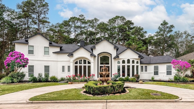 french country home featuring a front yard