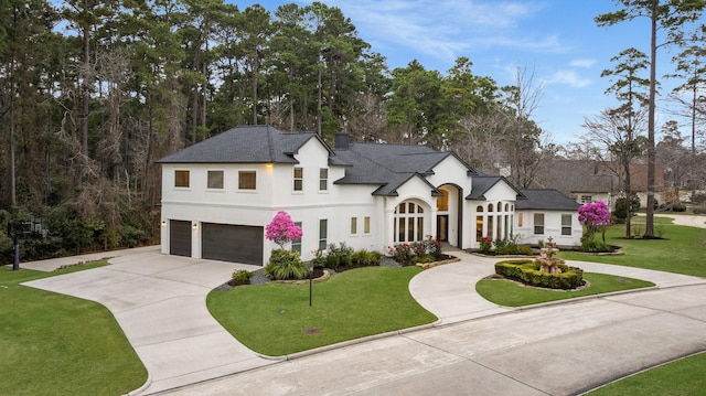 french country home with a front yard and a garage