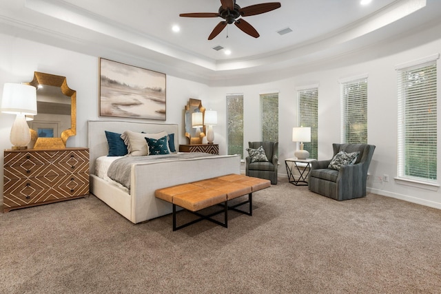 bedroom with a tray ceiling, ceiling fan, and carpet flooring