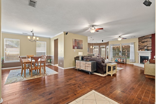 living room with ornamental molding, hardwood / wood-style floors, a fireplace, and a textured ceiling