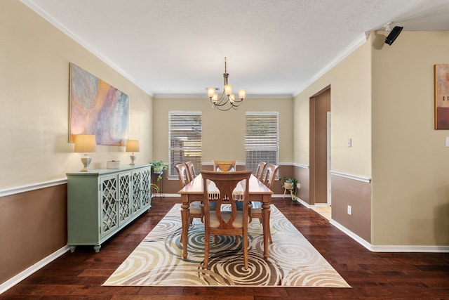 dining room featuring an inviting chandelier, dark wood-type flooring, a textured ceiling, and crown molding