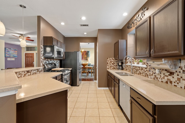 kitchen featuring sink, stainless steel appliances, dark brown cabinetry, and backsplash