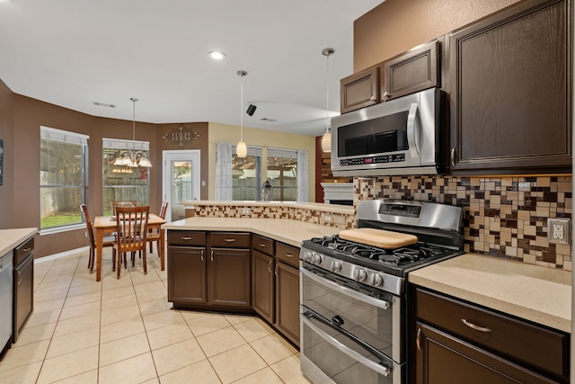 kitchen featuring stainless steel appliances, dark brown cabinetry, pendant lighting, and tasteful backsplash