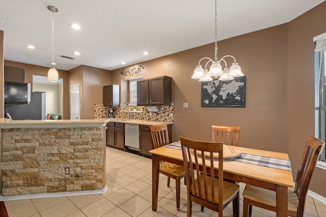 dining area with sink, an inviting chandelier, and light tile patterned floors