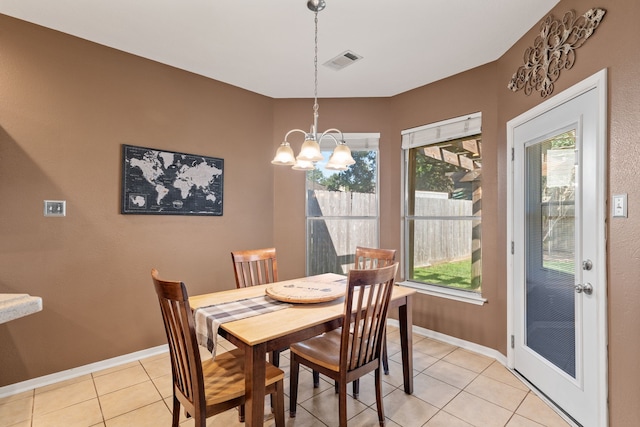 dining area with light tile patterned floors and a notable chandelier