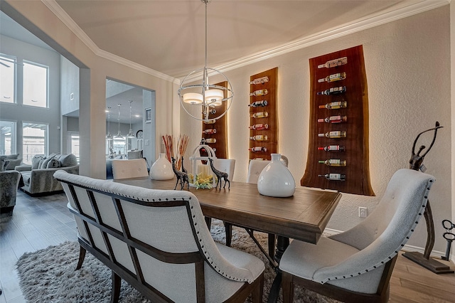 dining space featuring hardwood / wood-style flooring, a notable chandelier, and ornamental molding